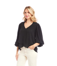 Load image into Gallery viewer, Woman wearing a black blouse and off-white pants against a white background.