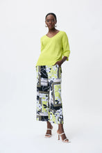 Load image into Gallery viewer, All eyes are on this striking lime green top designed by Joseph Ribkoff. Made from a lightweight summer sweater knit, our Lydia top offers a touchable texture that is super soft against the skin. A v split on each side is enhanced with silver rivet accents, while the V-neck design allows you to show off your favorite jewelry pieces. Color - Lime 3/4 Sleeve. Lightweight sweater knit.