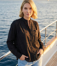 Load image into Gallery viewer, Woman standing on a boat with water in the background wearing a long sleeve embellished black shirt.