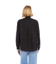 Load image into Gallery viewer, Woman wearing a black blouse with embellishments and light blue jeans on a white background.