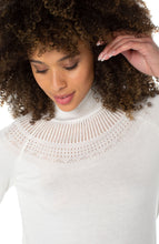 Load image into Gallery viewer, This timeless sweater is a classic blend of style and comfort. Crafted from a luxurious fabric in a porcelain white, with intricate pointelle stitching, it features a funnel neck and bell sleeves. Perfect for layering or wearing solo, it's a wardrobe essential. Color- Porcelain. Sweater yarn fabrication. Mock neckline. Bell sleeves. Pointelle detailing. Pullover construction.