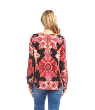 Load image into Gallery viewer, Woman wearing a colorful patterned blouse and blue jeans against a white background.