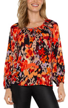 Load image into Gallery viewer, Experience the allure of nature with our elegant long-sleeve shirred woven blouse, featuring a lively burnt orange floral print. Made from a delicate woven fabric, this blouse flows beautifully, providing comfort and allowing breathability. This vibrant color top features long sleeves, ideal for day-to-evening wear, and its loose fit guarantees freedom of movement for lasting comfort.