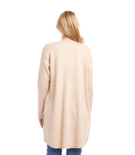 Load image into Gallery viewer, Woman wearing a long beige cardigan and blue jeans against a white background.