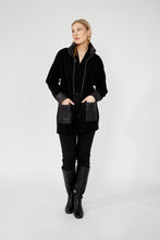 Load image into Gallery viewer, Woman wearing a long black jacket with rhinestone zipper black leggings and black boots against a white background.