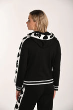 Load image into Gallery viewer, Woman wearing a black and white patterned jacket with hoodie and matching pant on a white background.