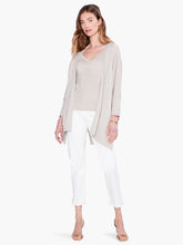 Load image into Gallery viewer, Worn open or tied at the front, this lightweight relaxed-fit cardigan brings draped comfort and style to any outfit. Designed to sit slightly below the hip with an 3/4 length sleeves. Made with a soft, breathable T-shirt yarn with metallic lurex added in to give it just the right amount of shine. Color- Light sand. Subtle sparkle throughout. Cape design. Lurex yarn, wear open or tied. Lightweight.