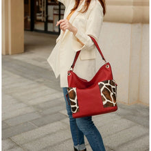 Load image into Gallery viewer, Crafted from superior vegan leather, this hobo bag features stylish gold-tone hardware and a slouchy silhouette. Boasting a spacious interior with a mid-centered zipper pocket, two slip in pockets, and a wall zipper pocket, the bag is also designed with two slip-in pockets on either side in a fashionable animal print.