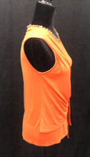 Load image into Gallery viewer, This wrinkle-free top effortlessly takes you from day to night with its carefully positioned side drape detail that sculpts and flatters your body shape. Made with a blend of rayon and spandex, this top not only feels soft against your skin, but also provides a stretch that enhances your silhouette. The brilliant solid orange color coordinates perfectly with a number of trousers, skirts and shorts and looks fabulous with denim.