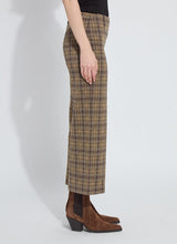 Load image into Gallery viewer, Model wearing brown plaid sparkle pants and brown suede boots against a white background.
