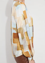 Load image into Gallery viewer, Crafted from two-way stretch Hammered Silk-Touch Satin, the Marie Blouse features an open neckline, asymmetrical front pleats, a high-low hemline, and double-box pleats on the sleeves for added volume. It fits true to size and pairs well with Ankle Elysse Vegan Leather pants in chalk and ankle boots. To remove any wrinkles after delivery, a gentle steaming or ironing is recommended.