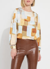 Load image into Gallery viewer, Crafted from two-way stretch Hammered Silk-Touch Satin, the Marie Blouse features an open neckline, asymmetrical front pleats, a high-low hemline, and double-box pleats on the sleeves for added volume. It fits true to size and pairs well with Ankle Elysse Vegan Leather pants in chalk and ankle boots. To remove any wrinkles after delivery, a gentle steaming or ironing is recommended.