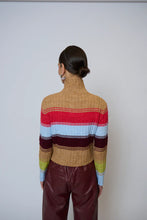 Load image into Gallery viewer, Woman wearing a colorful striped sweater and burgundy faux leather pants against a plain background.