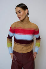 Load image into Gallery viewer, Woman wearing a colorful striped sweater and burgundy faux leather pants against a plain background.
