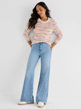 Load image into Gallery viewer, Woman wearing a colorful sweater, blue jeans and sneakers against a white background.