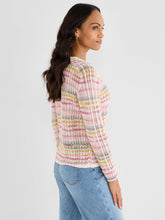 Load image into Gallery viewer, Woman wearing a colorful sweater and blue jeans against a white background.
