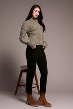 Load image into Gallery viewer, Woman wearing a green sweater and deep, dark green cord pants with brown boots standing next to a barstool against a plain background.
