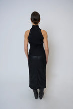 Load image into Gallery viewer, Woman wearing a black sleeveless top, leather skirt and black boots against a white background.