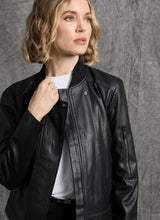 Load image into Gallery viewer, Woman wearing a black leather jacket and white tee against a gray background.