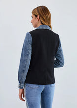 Load image into Gallery viewer, Woman wearing a black blazer with denim sleeves and collar and blue jeans against a white background.