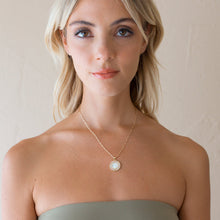 Load image into Gallery viewer, Woman wearing a gold necklace with a pendant against a neutral background.