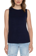 Load image into Gallery viewer, Woman wearing a navy sleeveless ribbed tank and blue jeans against a white background.