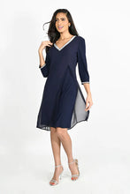 Load image into Gallery viewer, This beautiful V-neck dress comes in a luxurious navy shade with sparkling rhinestone trim along the front neckline and sleeves. The elegant chiffon split in the front offers a flowing look ideal for any special occasion. An absolute timeless classic. Color -Midnight blue with clear crystals. V-Neck. Chiffon overlay. Split fabrication in front. Crystal detailing at neckline and cuffs. Long sleeve. Knit/Woven Dress Fabric -95% Polyester. 5% Elasthane.