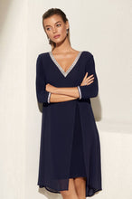 Load image into Gallery viewer, This beautiful V-neck dress comes in a luxurious navy shade with sparkling rhinestone trim along the front neckline and sleeves. The elegant chiffon split in the front offers a flowing look ideal for any special occasion. An absolute timeless classic. Color -Midnight blue with clear crystals. V-Neck. Chiffon overlay. Split fabrication in front. Crystal detailing at neckline and cuffs. Long sleeve. Knit/Woven Dress Fabric -95% Polyester. 5% Elasthane.