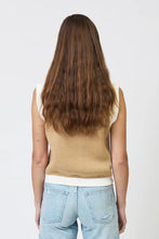 Load image into Gallery viewer, Woman wearing a sand-colored sleeveless sweater vest with beige pants on a plain background.