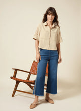 Load image into Gallery viewer, The Noah Hi Waist Crop Wide Fringe Denim is carefully crafted with two-color tobacco topstitching, a fringed hem, beltloops, back pockets, and a self-fringe insert on the side seams to provide an authentic denim look. Made from "Holding Power" Denim, this woven denim adapts to all shapes for maximum comfort and flattering fit. With a concealed patented waistband, two-way stretch, and pull-on styling, these must-have jeans are fitted through the waist and hip with a wide, cropped leg.