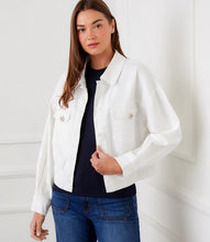 Load image into Gallery viewer, Woman wearing a white jacket over a black top and blue jeans against a white background.