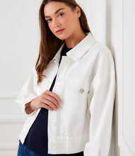 Load image into Gallery viewer, Woman wearing a white jacket with a small decorative button on front pocket, standing against a white wall.