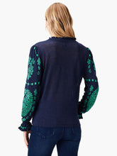 Load image into Gallery viewer, Woman wearing a navy-blue sweater with green floral patterns on long sleeves.