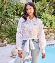 Load image into Gallery viewer, This lovely top is constructed with cotton fabric, allowing for softness and breathability. It showcases a floral embroidery in an eyelet design, elevating any ensemble with a touch of sophistication and femininity.