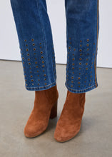 Load image into Gallery viewer, Close-up of metallic rivet details at the hems of blue jeans and brown suede boots against a neutral background.