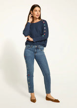 Load image into Gallery viewer, Expertly crafted with a nod to floral fashion, these Olivia Pencil Ankle Denim in Medium Wash, project understated chic. Delicate flower embellishments adorn the outer side of each leg, adding a distinct touch. The classic pencil cut flatters the figure and offers a sleek and modern silhouette.
