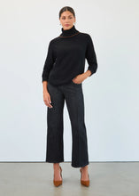 Load image into Gallery viewer, Woman wearing dangling earrings, a black turtleneck sweater, black wash jeans and brown heels against a white background.