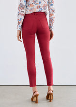 Load image into Gallery viewer, Woman wearing a floral blouse, red slim ankle jeans and brown heels against a white background.