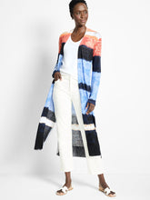 Load image into Gallery viewer, Woman wearing a colorful striped cardigan over a white top and pants against a white background.