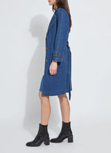 Load image into Gallery viewer, Woman wearing a blue denim trench coat and black boots against a white background.