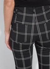 Load image into Gallery viewer, Model wearing black and off-white plaid pants against a white background.
