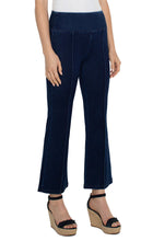 Load image into Gallery viewer, Model wearing dark blue ankle flare, pull on denim and black high heeled sandals against a white background.