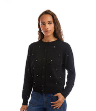 Load image into Gallery viewer, Woman wearing a black sweater with pearl embellishments and blue jeans against a white background.