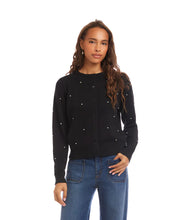 Load image into Gallery viewer, Woman wearing a black sweater with pearl embellishments and blue jeans against a white background.