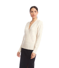 Load image into Gallery viewer, Woman wearing a cream v-neck sweater with pearls and black skirt against a white background.