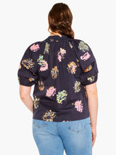 Load image into Gallery viewer, Sometimes it's all in the name! This dramatic combo of dark background and powerful pops of color on this stunning top is an outfit scene stealer, a real conversation piece. It's not just the firework display design though: we love the layered details on the short sleeves, the easy elastic cuffs, the frilled split neck, and the tie front. Dress it up with professional workpants or keep things casual with denim.