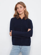 Load image into Gallery viewer, Woman wearing a navy cardigan with a faux fur collar and light blue jeans against a white background.