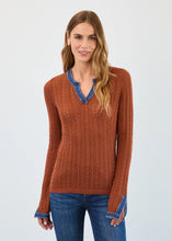 Load image into Gallery viewer, Woman wearing a bronze sweater with blue trim and blue jeans against a white background.