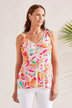 Load image into Gallery viewer, Woman wearing a bright multicolored shoulder tie tank top and white pants against a white background with a palm plant.
