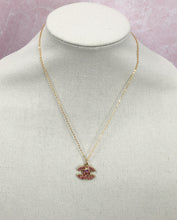 Load image into Gallery viewer, Stunning sparkle describes the Prudence Pink and Gold Vintage Coco Chanel Zipper Pull Necklace. With a gold border and spectacular pink gemstones, this brilliant style will get you noticed and give you compliments. Attached is a small pink crystal to add extra sparkle which can easily be detached if desired.